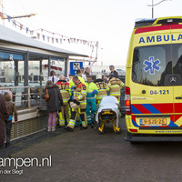Man te water tussen schip en IJsselkade in Kampen